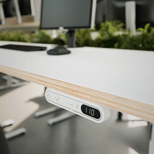 高度可调的升降办公桌，桌面下方装有白色的现代化DPF1C 控制器