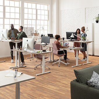 在现代办公室，办公人员可在符合人体工学的升降办公桌前坐站交替式办公 